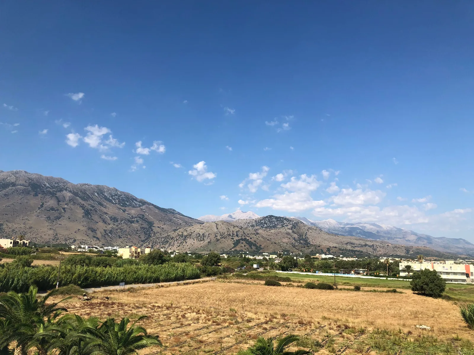 A wide flat farming plateau ringed by bare mountains in eastern Crete