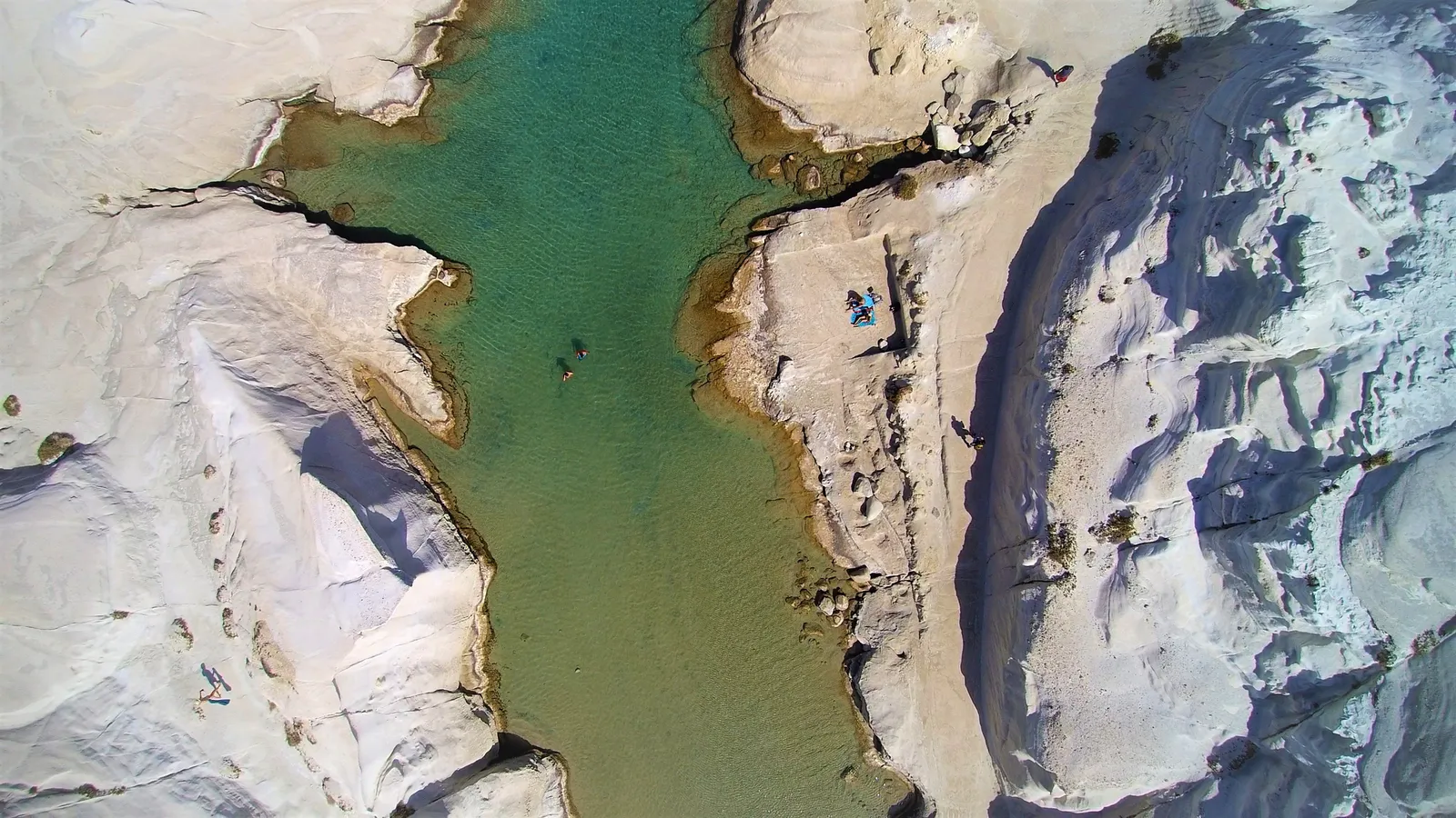 Smooth white volcanic rock formations meeting deep blue sea at Sarakiniko on Milos