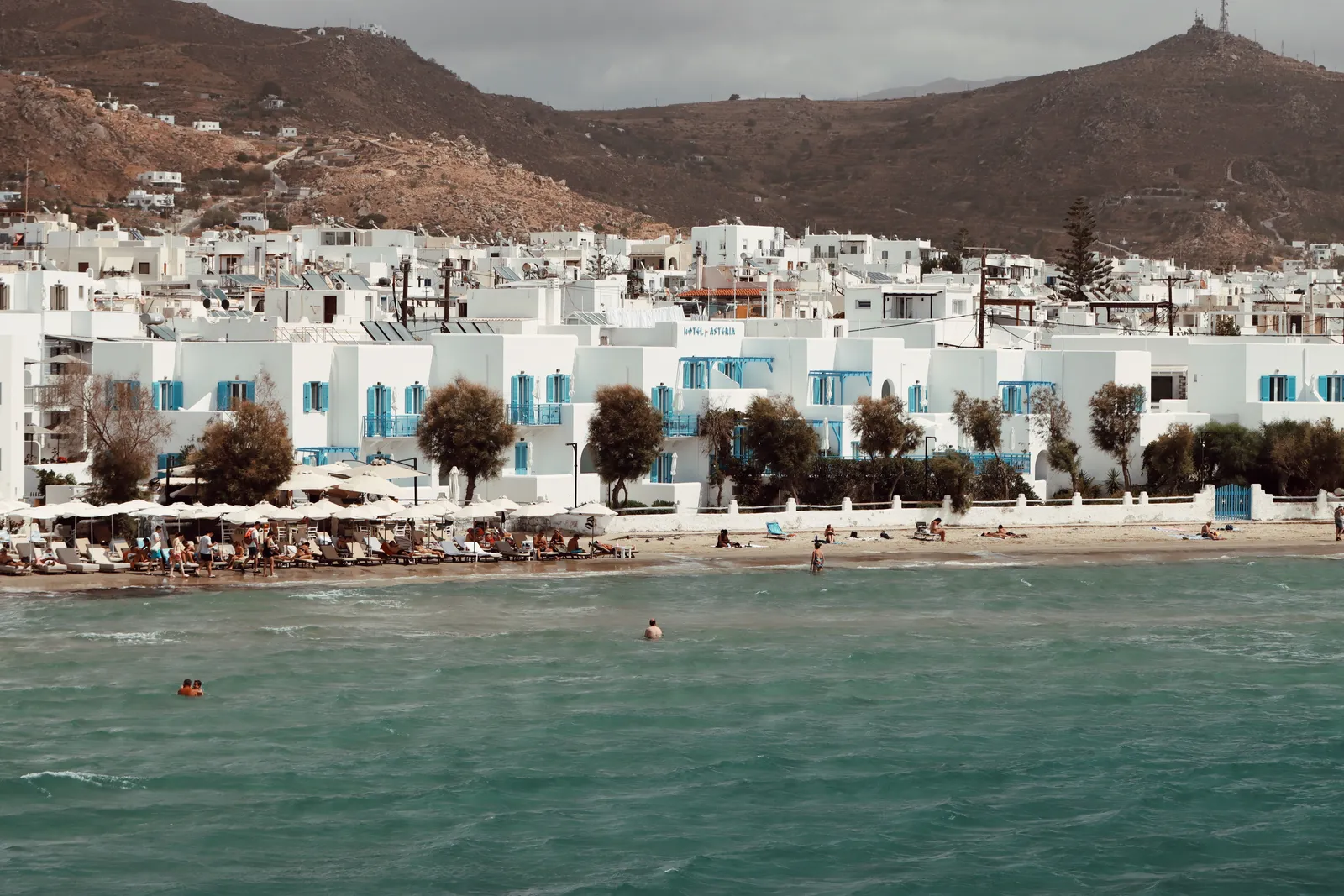 A sandy beachfront backed by whitewashed buildings and trees on Naxos