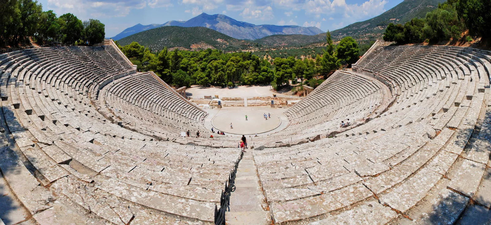 The stone tiers of the ancient theatre of Epidaurus rising in a wide semicircle above the empty orchestra, Peloponnese, Greece
