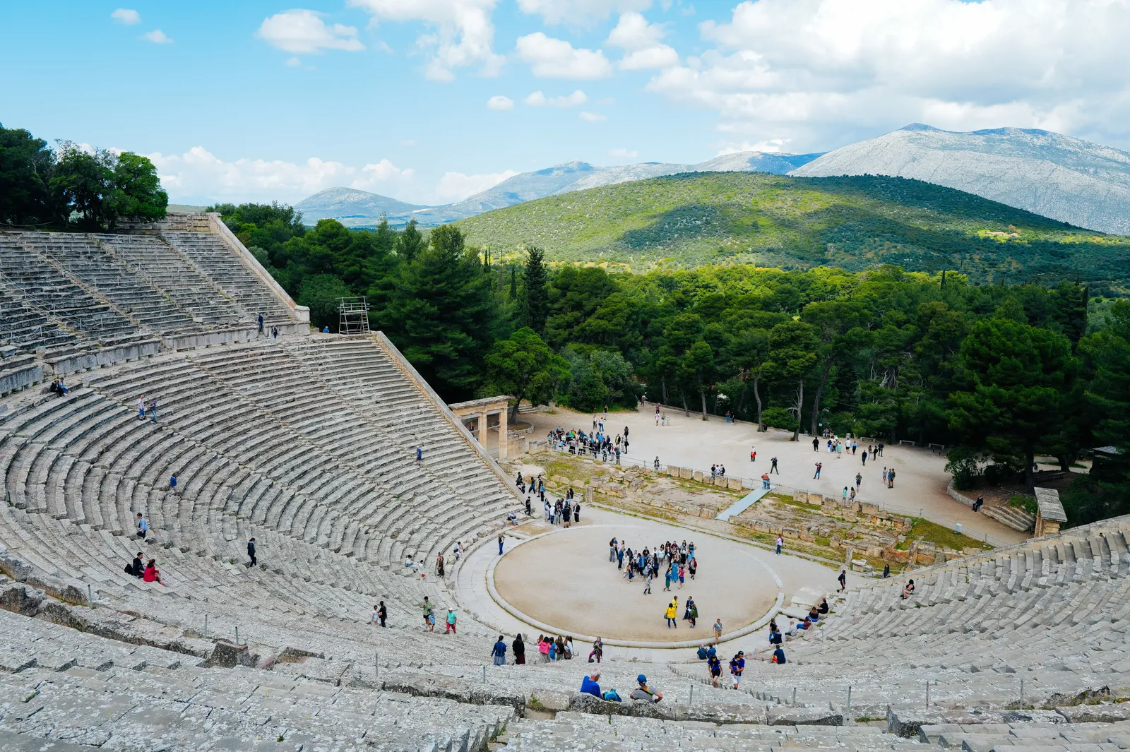 The circular stone orchestra of the ancient theatre of Epidaurus seen from the top row of seating, Peloponnese, Greece