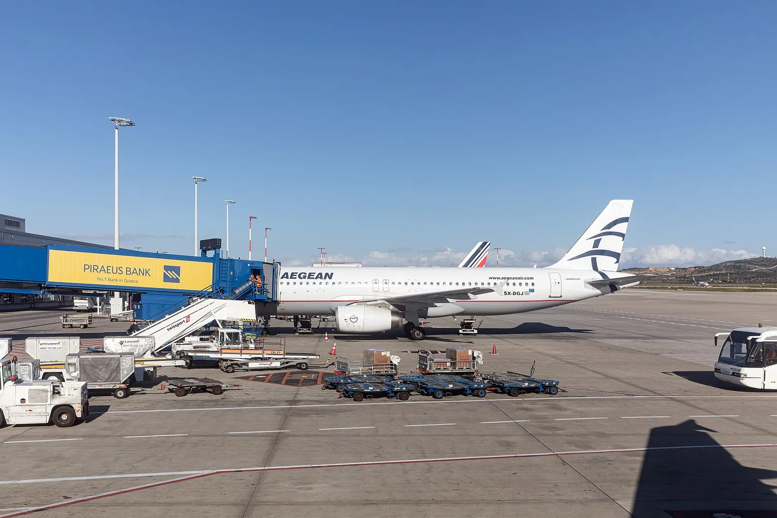 An Aegean Airlines jet parked at its gate at Athens International Airport on a clear day