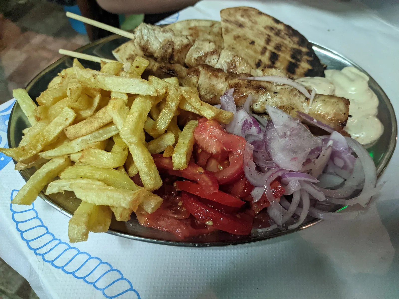 שולחן עמוס מנות אוכל יווני מסורתי עם סלט פטה צזיקי וזיתים בטברנה ביוון