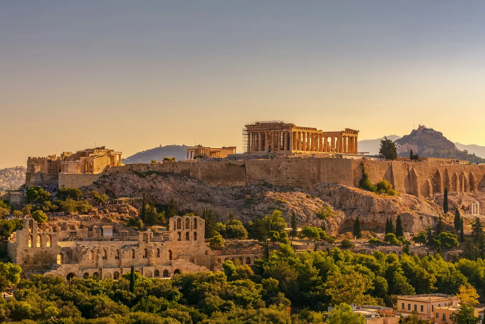 The Parthenon on the Acropolis of Athens glowing at sunset above the city rooftops