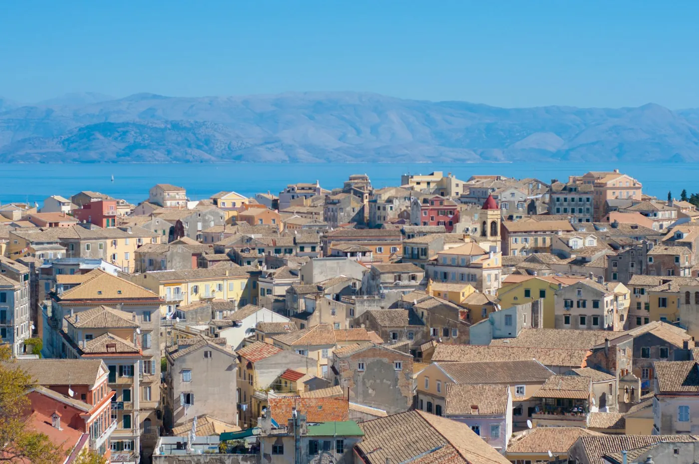 Aerial view of Corfu Old Town, Greece, showing terracotta Venetian rooftops and the sea