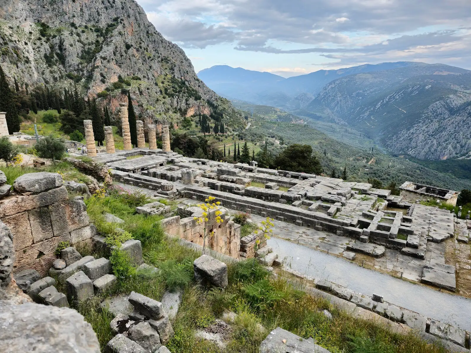 The Temple of Apollo columns at Delphi with the slopes of Mount Parnassus behind, Greece