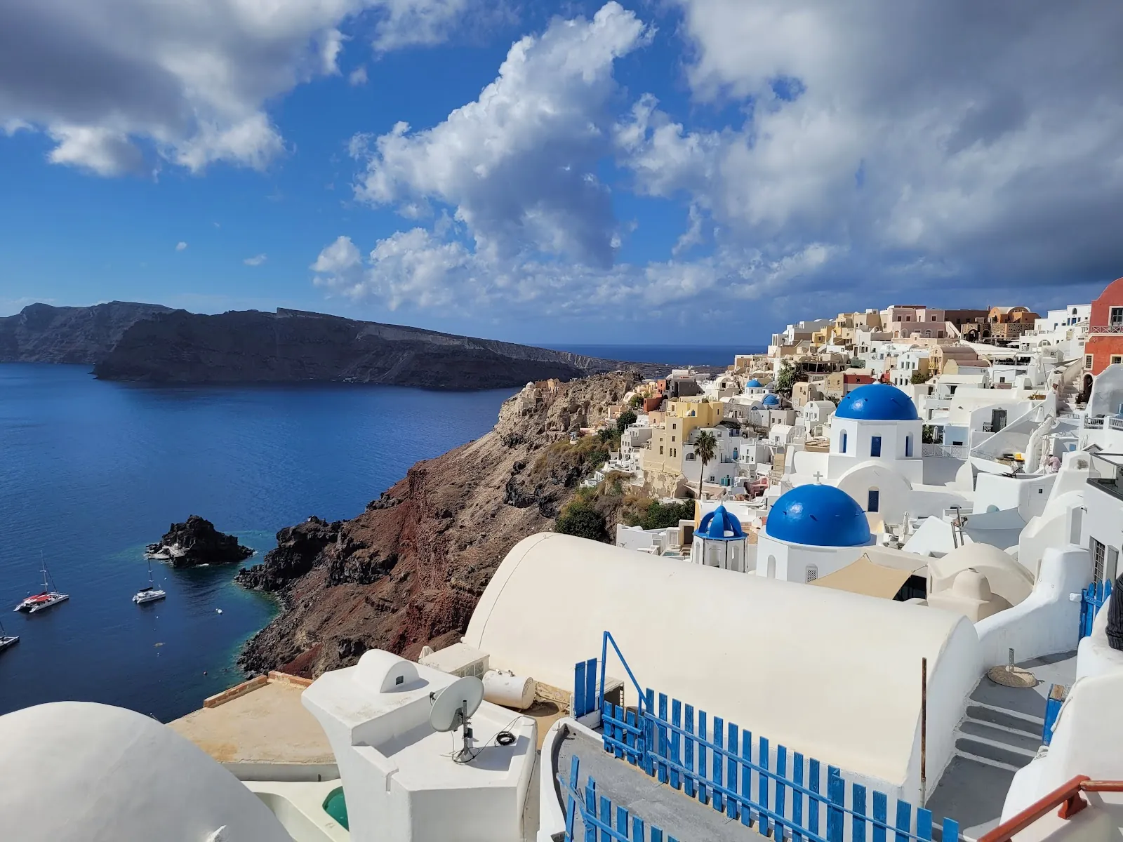 Whitewashed cliff-top houses and blue domes overlooking the caldera in Oia, Santorini, Greece