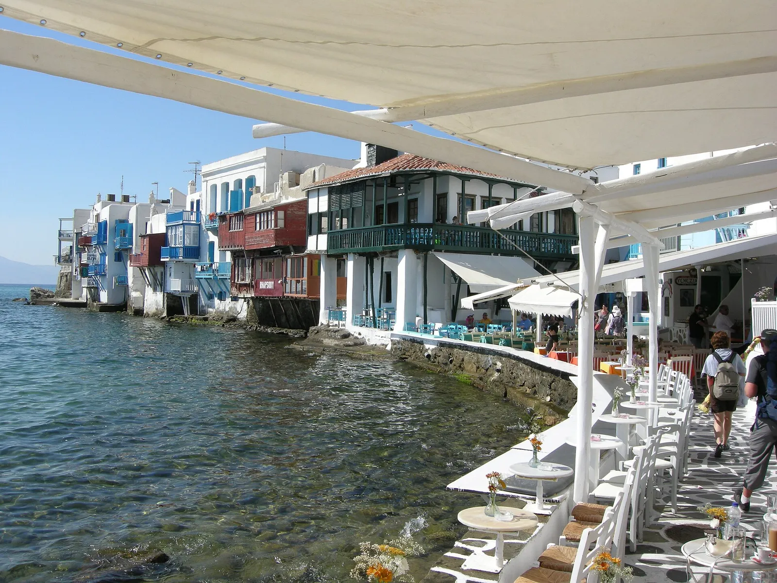 Bars and houses standing right at the water's edge in the Little Venice quarter of Mykonos Town, Greece