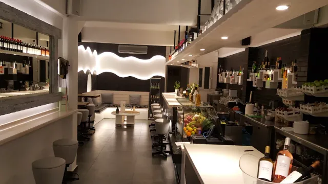 A modern black and white space with a long counter, stools and a fruit display