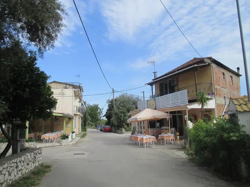 The village street at Rachi on Lefkada, with tables under an awning at the edge of the slope