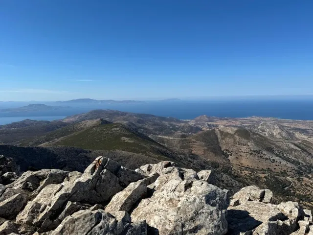 White rocks at a summit and a view over ridges, sea and distant islands on the horizon