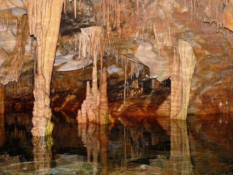 Stalactite columns in the Diros Caves, reflected in the underground lake