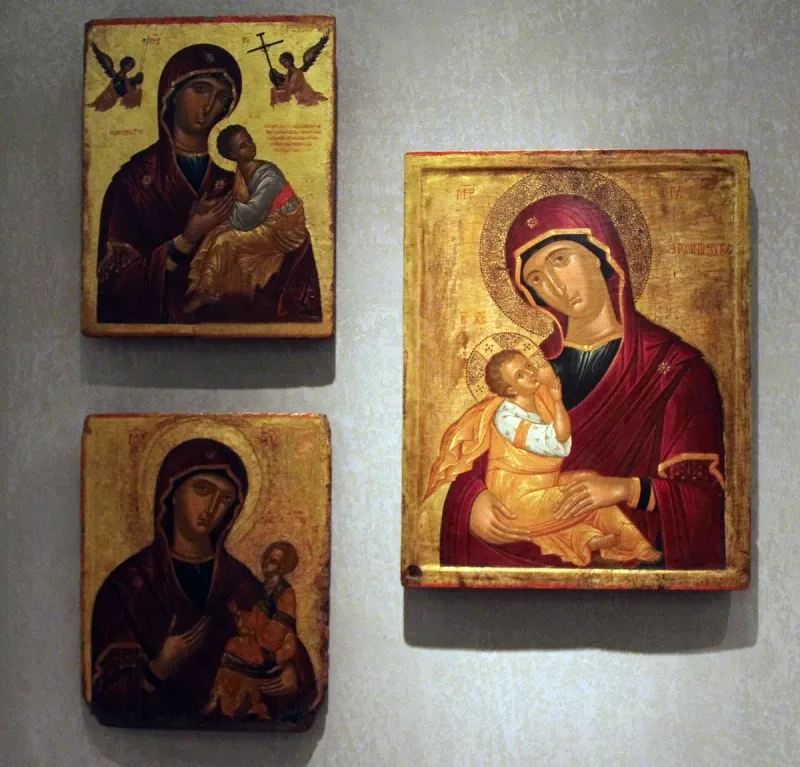 Three gilded Byzantine icons hanging on a gallery wall