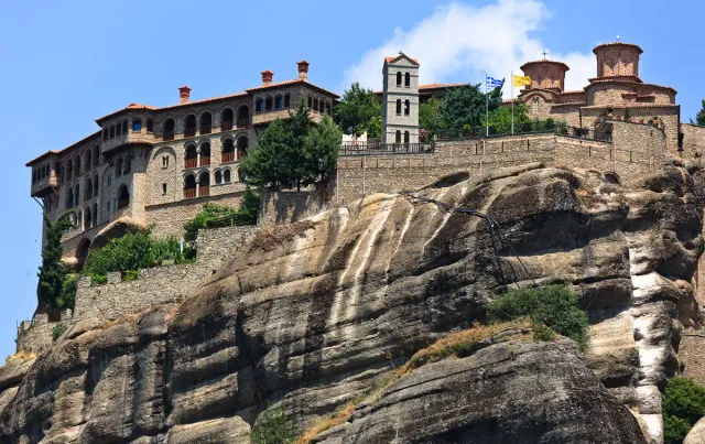 A stone monastery built on the summit of a towering rock pillar