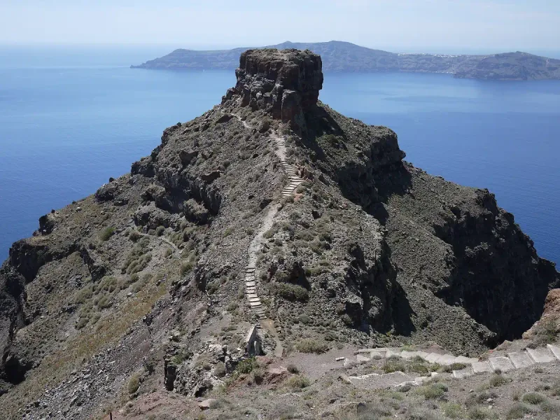 A jagged volcanic headland jutting into deep blue sea