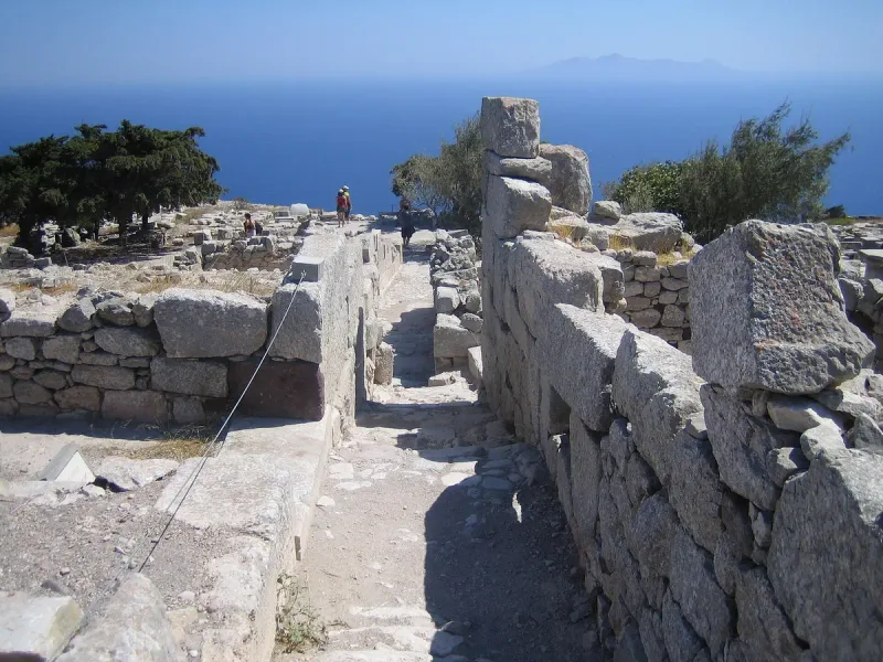 Rows of ancient foundation stones on a high ridge with deep blue sea below