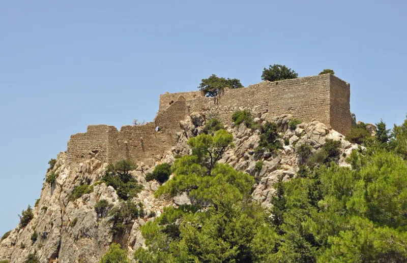 The walls of Monolithos castle on Rhodes, on a rock crag among pines