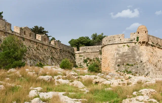 Long stone fortress walls with bastions, on a hill above the town