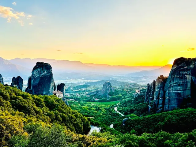 The rocks of Meteora at sunset, with a monastery on one of the pinnacles