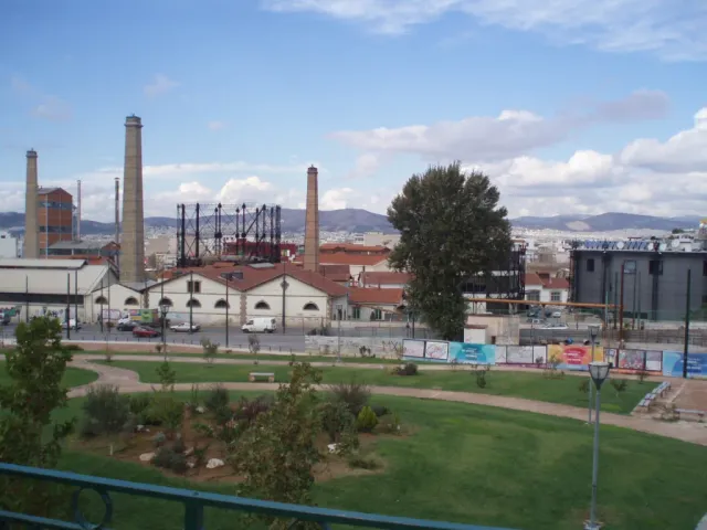 A preserved industrial complex with red brick chimneys and a lawn in front