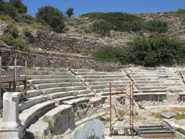 Rows of white marble seats of an ancient theatre on a slope