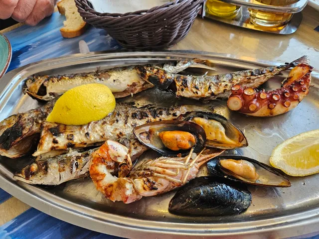 A platter of grilled fish, mussels, shrimp and octopus with lemon wedges