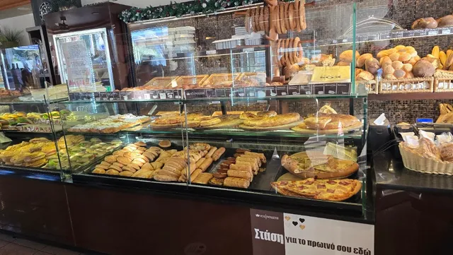 Display cases full of pastries, breads and pizzas behind glass