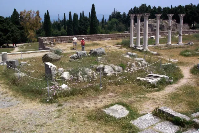 A terrace of an ancient site with a restored row of columns and scattered stones