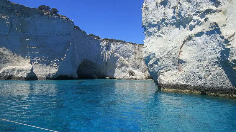 White limestone cliffs and rock arches above calm turquoise water