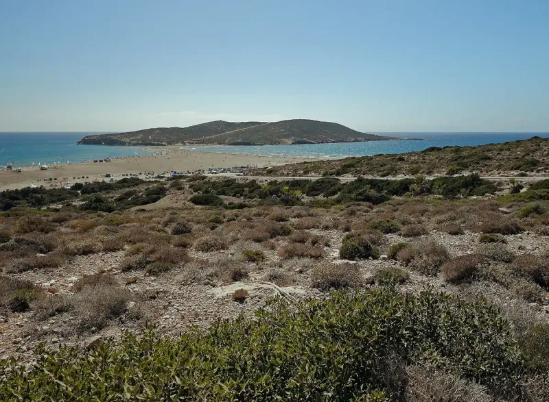A narrow sand spit linking the shore to a hill out in the sea
