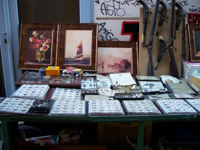 A street antiques stall with framed pictures and curios