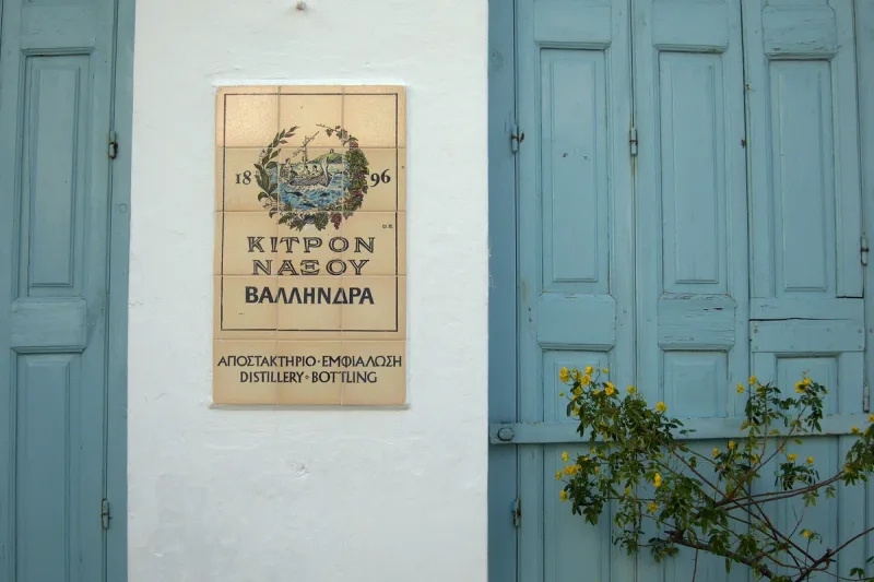 The sign and turquoise doors at the entrance to the kitron distillery in Halki on Naxos