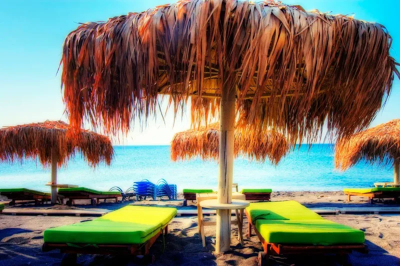 Straw umbrellas and sun loungers on Perivolos beach in Santorini