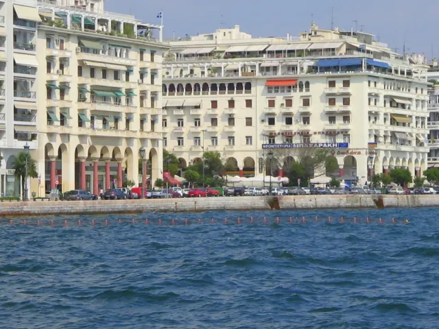A uniform row of building fronts facing the sea, with a quay and promenade before it